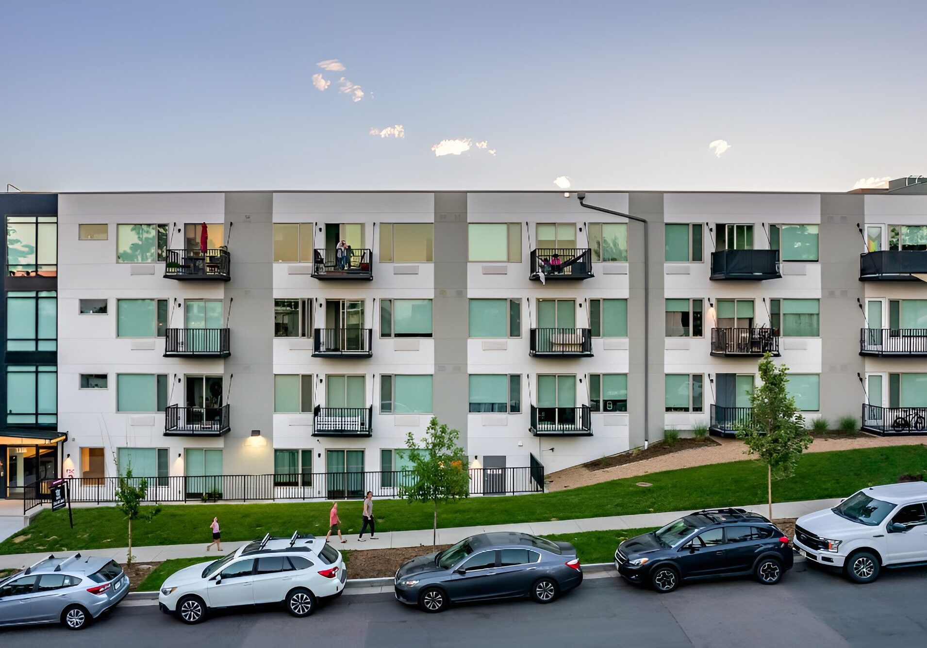 Modern apartment building with balconies and parked cars